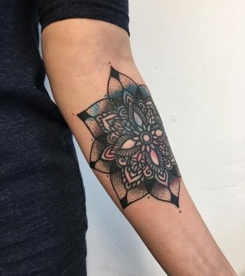  Tatouage mandala avec des touches de bleu et de rose au milieu du bras